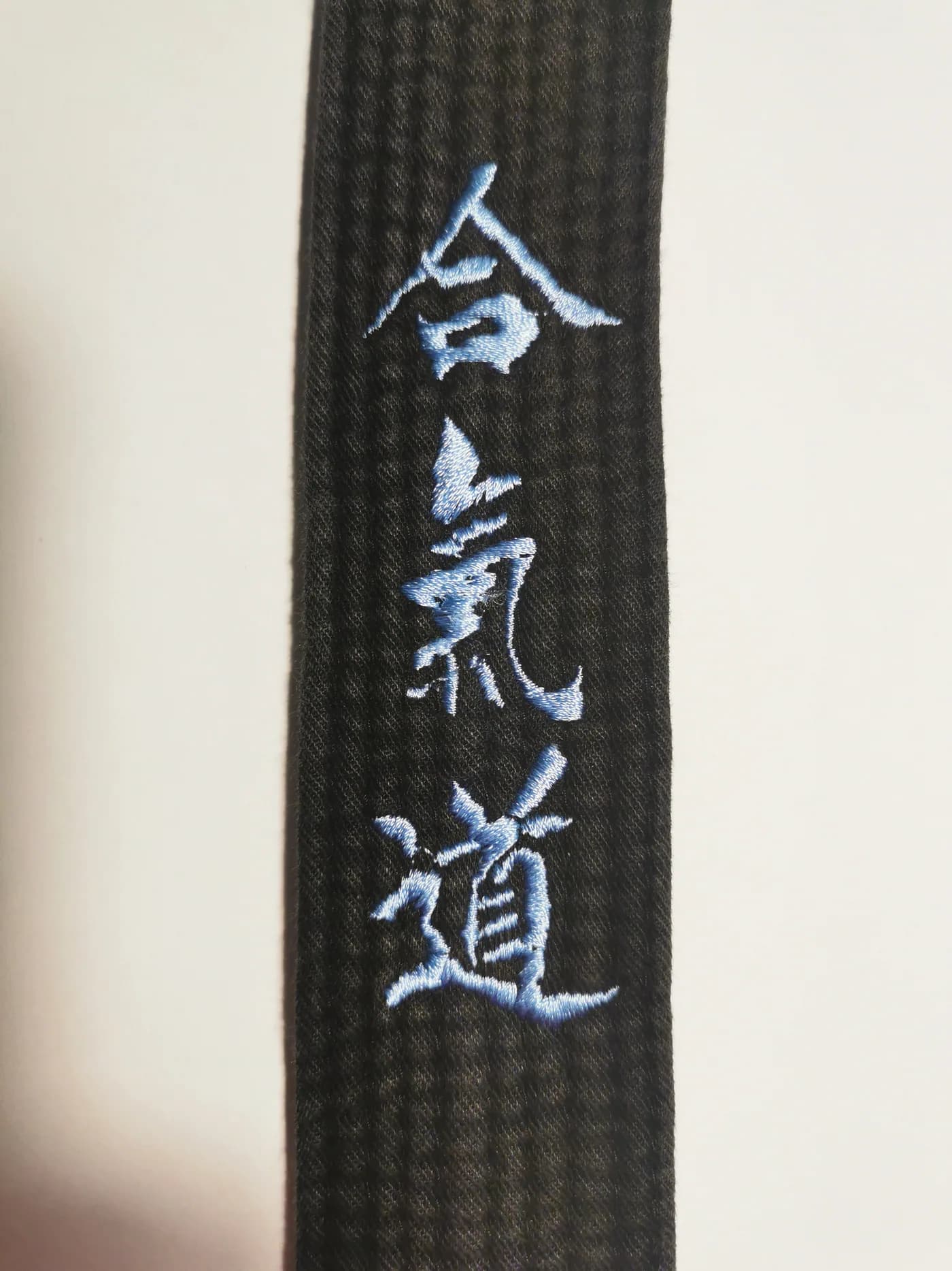 Broderie de kanji sur ceinture noire, vue de près
