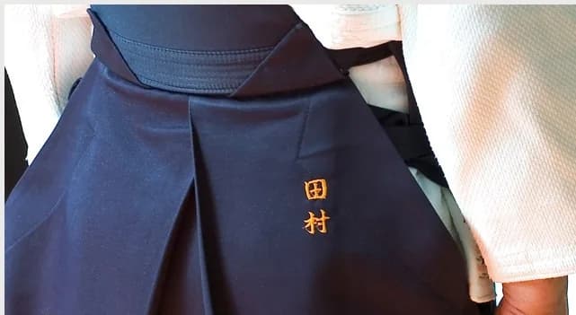 Hakama porté avec broderie sur la hanche