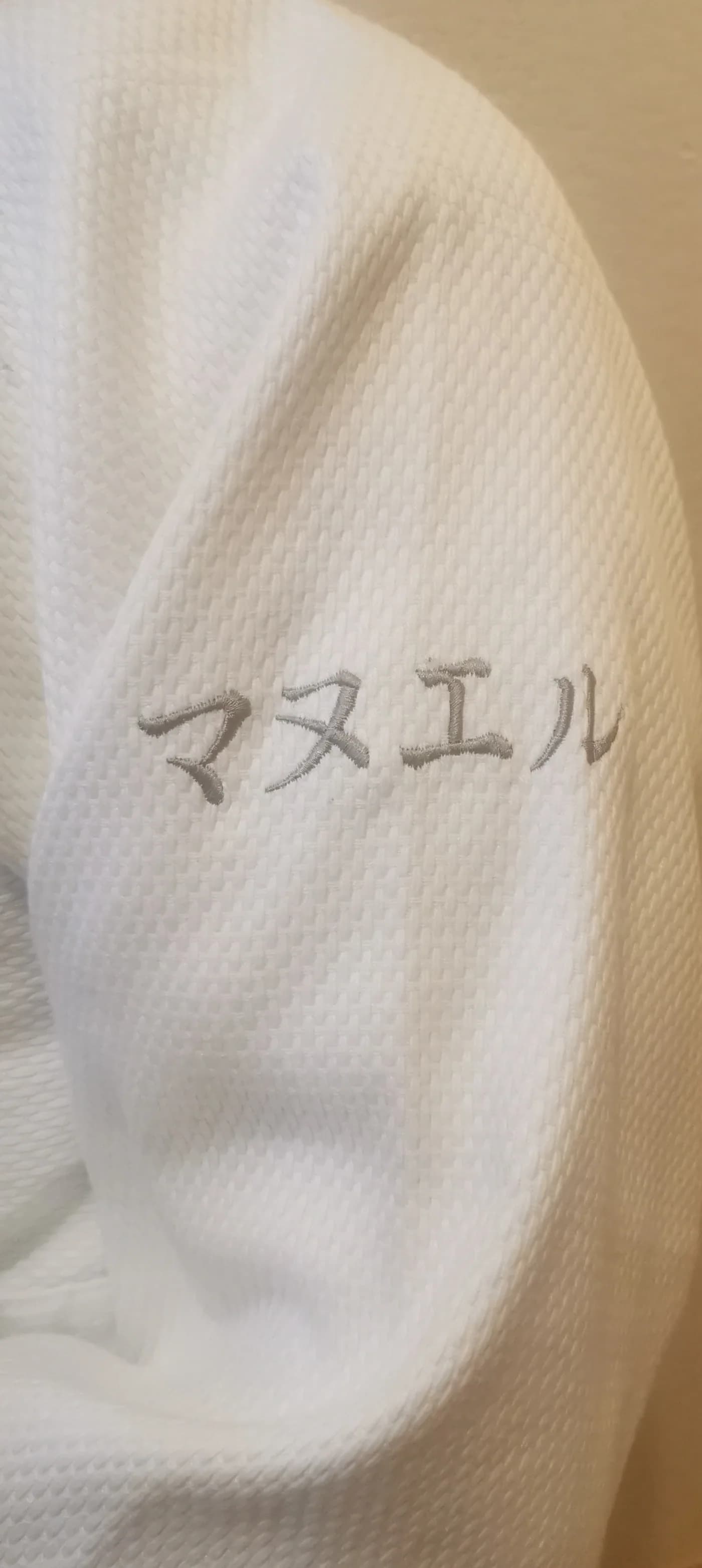 Prénom en katakana brodé sur la manche gauche du keikogi porté